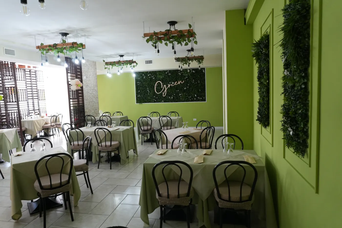 La sala del Green Restaurant, con le pareti verdi e i tavoli apparecchiati
